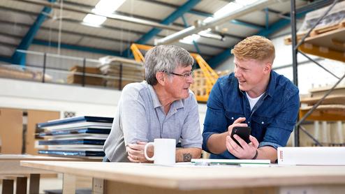 Beratschlagung in Werkstatt Zwei Männer beratschlagen sich in Werkstatt